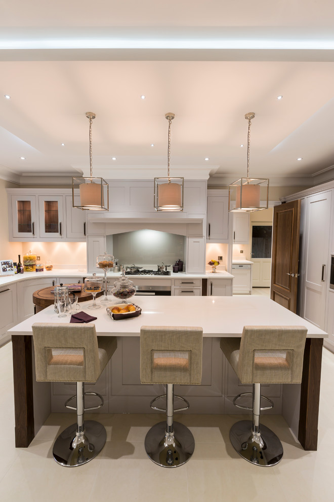 Design ideas for a traditional u-shaped enclosed kitchen in Surrey with shaker cabinets, white cabinets, grey splashback, integrated appliances and an island.