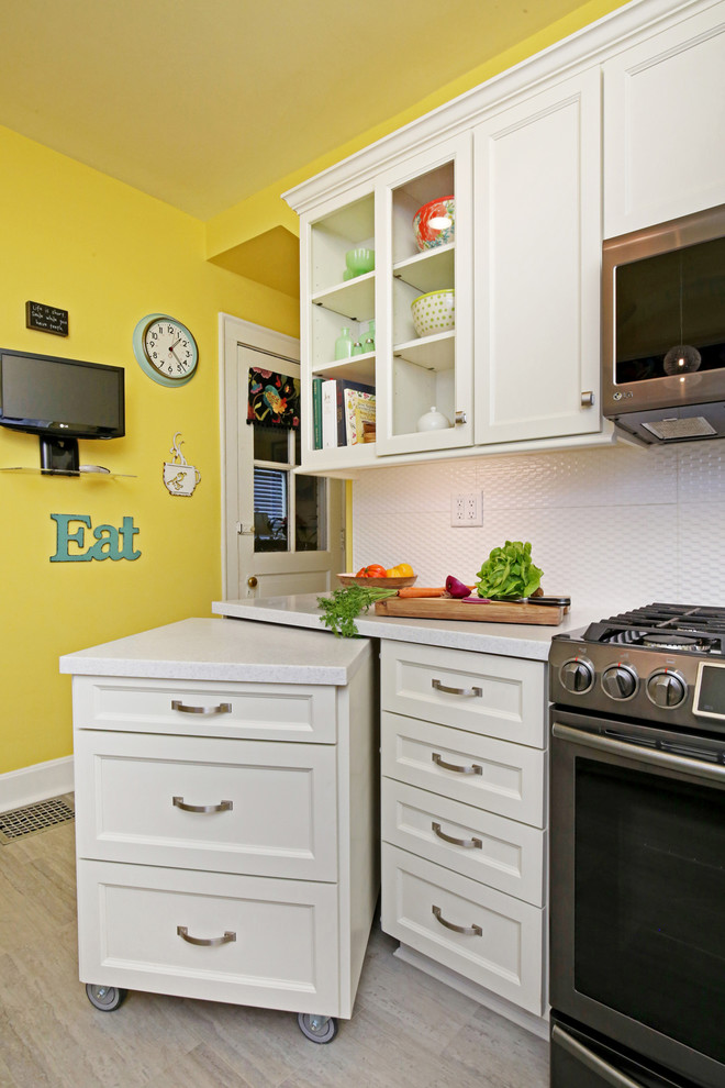 ルイビルにある低価格の小さなトランジショナルスタイルのおしゃれなキッチン (ダブルシンク、落し込みパネル扉のキャビネット、白いキャビネット、人工大理石カウンター、白いキッチンパネル、セラミックタイルのキッチンパネル、シルバーの調理設備、クッションフロア、アイランドなし、グレーの床、白いキッチンカウンター) の写真