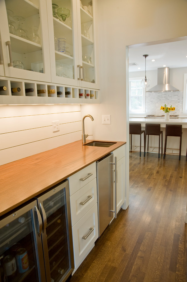 Example of a large transitional dark wood floor and brown floor kitchen pantry design in Boston with a double-bowl sink, shaker cabinets, white cabinets, quartzite countertops, gray backsplash, stainless steel appliances and an island
