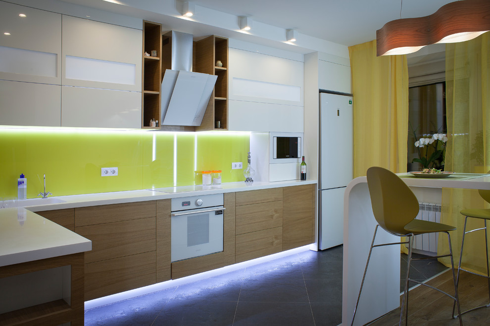 Modelo de cocina retro grande con fregadero integrado, armarios tipo vitrina, salpicadero amarillo, salpicadero de vidrio templado y suelo de travertino