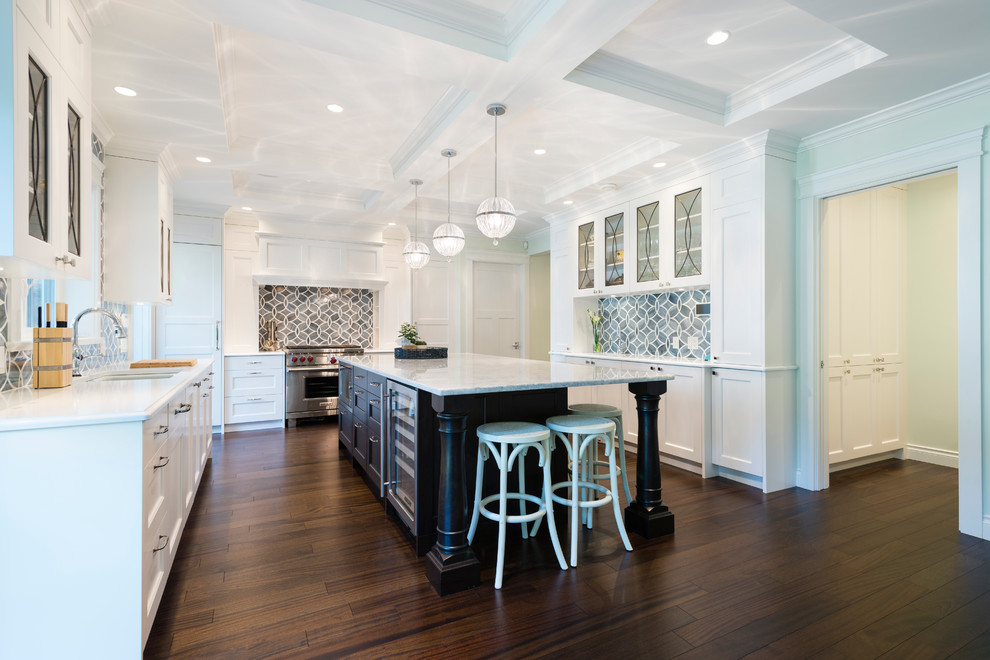 Inspiration for a large transitional u-shaped dark wood floor open concept kitchen remodel in Vancouver with an undermount sink, shaker cabinets, white cabinets, quartzite countertops, blue backsplash, glass tile backsplash, paneled appliances and an island