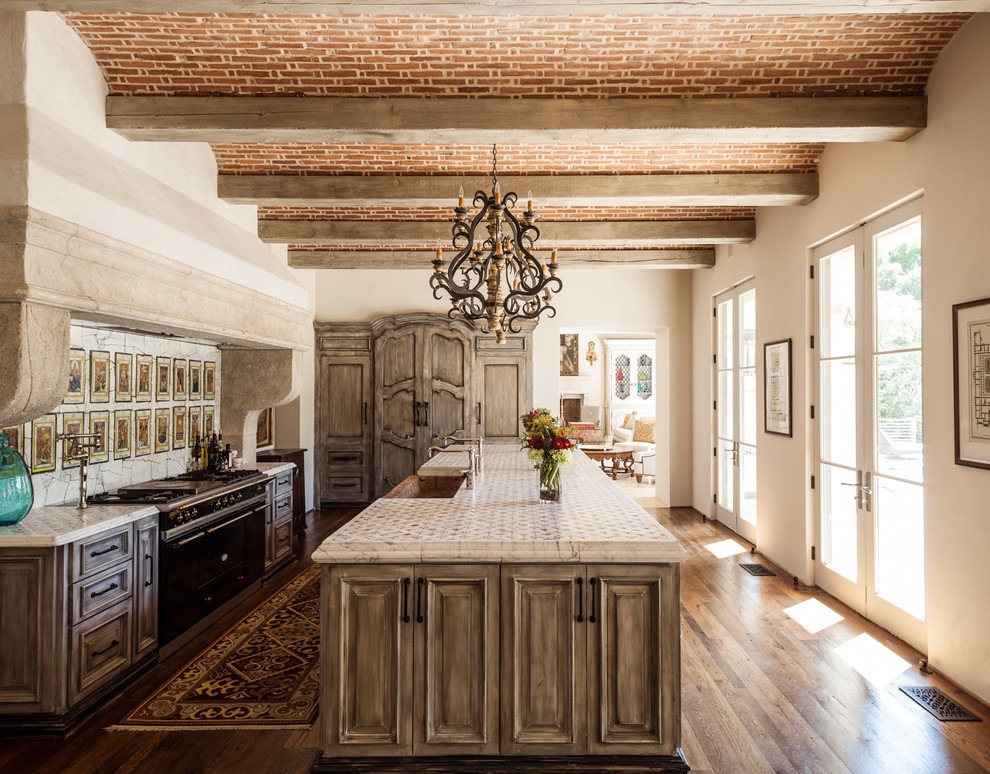 Photo of a mediterranean kitchen in Dallas with raised-panel cabinets, medium wood cabinets and black appliances.