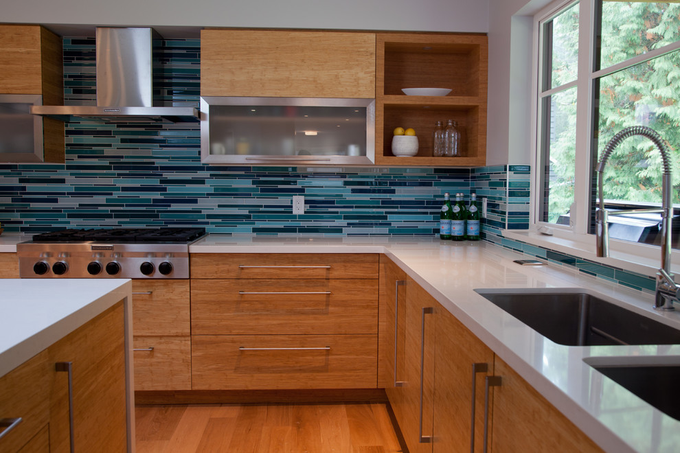 Trendy kitchen photo in Vancouver with flat-panel cabinets, light wood cabinets, quartz countertops, blue backsplash, matchstick tile backsplash, stainless steel appliances and a double-bowl sink
