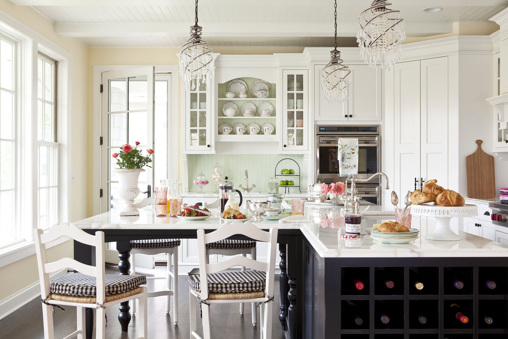 Klassisk inredning av ett mellanstort kök, med luckor med infälld panel, vita skåp, en undermonterad diskho, marmorbänkskiva, grönt stänkskydd, rostfria vitvaror, mörkt trägolv och en köksö