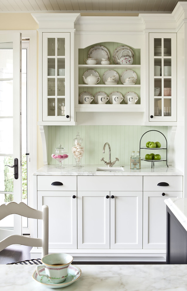 Example of a mid-sized classic kitchen design in Minneapolis with an undermount sink, white cabinets, marble countertops, green backsplash and glass-front cabinets