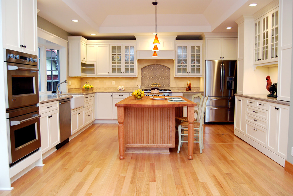 Inspiration för mellanstora lantliga kök, med en rustik diskho, luckor med infälld panel, vita skåp, flerfärgad stänkskydd, rostfria vitvaror, bänkskiva i kvarts, stänkskydd i stenkakel, mellanmörkt trägolv, en köksö och brunt golv