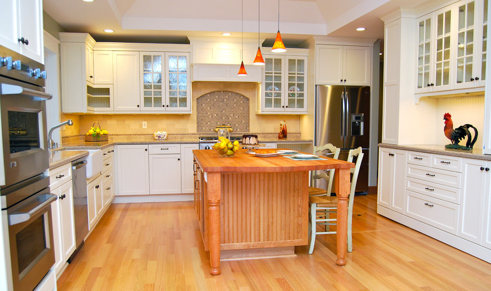Idéer för ett mellanstort lantligt kök, med en rustik diskho, luckor med infälld panel, vita skåp, bänkskiva i kvarts, flerfärgad stänkskydd, rostfria vitvaror, stänkskydd i stenkakel, mellanmörkt trägolv, en köksö och brunt golv