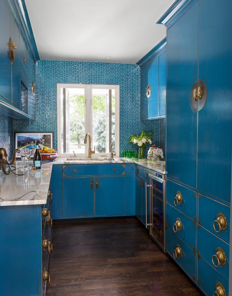 Eklektisk inredning av ett grå grått u-kök, med en undermonterad diskho, släta luckor, blå skåp, blått stänkskydd, rostfria vitvaror och mörkt trägolv