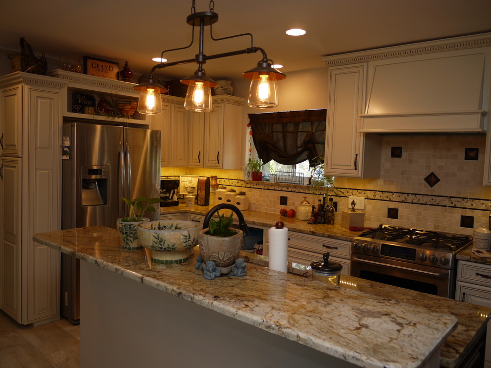 Exempel på ett klassiskt kök, med en dubbel diskho, luckor med upphöjd panel, granitbänkskiva, rostfria vitvaror, klinkergolv i keramik och en köksö