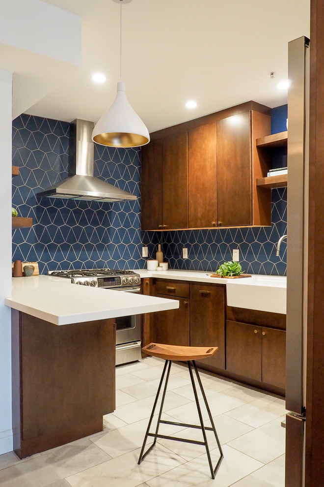Design ideas for a medium sized retro u-shaped enclosed kitchen in San Francisco with a belfast sink, stainless steel appliances, beige floors, flat-panel cabinets, dark wood cabinets, blue splashback, ceramic flooring, no island and white worktops.