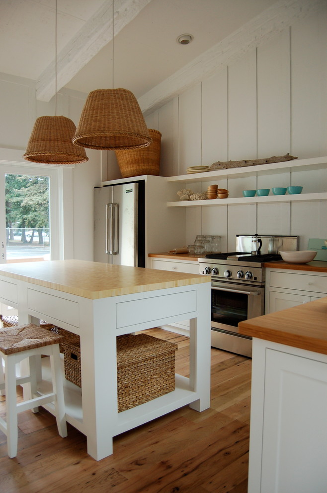 Immagine di un grande cucina con isola centrale design con elettrodomestici in acciaio inossidabile, top in legno, ante in stile shaker, ante bianche e parquet chiaro