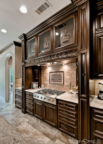 Exempel på ett klassiskt kök, med en undermonterad diskho, luckor med upphöjd panel, skåp i mörkt trä, granitbänkskiva, stänkskydd i stenkakel, rostfria vitvaror, klinkergolv i porslin och en köksö