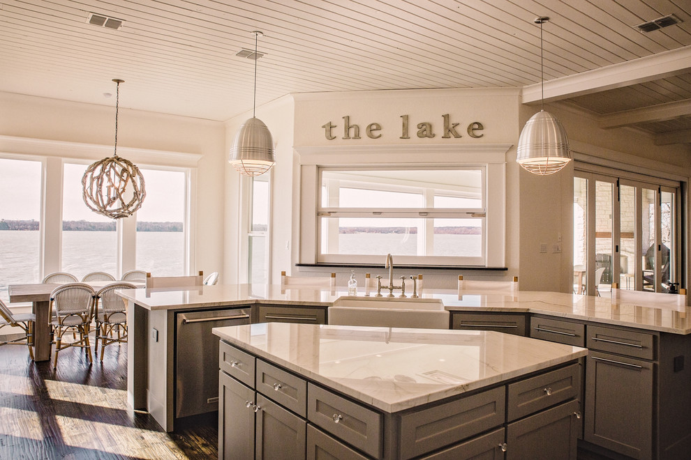 Open concept kitchen - large coastal l-shaped dark wood floor and brown floor open concept kitchen idea in Dallas with a farmhouse sink, shaker cabinets, white cabinets, marble countertops, white backsplash, ceramic backsplash, stainless steel appliances and two islands