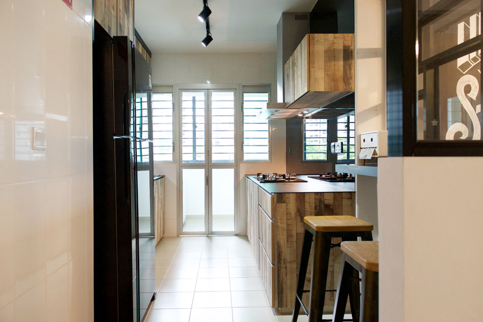 Kitchen pantry - industrial kitchen pantry idea in Singapore with a single-bowl sink, medium tone wood cabinets, tile countertops, black backsplash and glass sheet backsplash