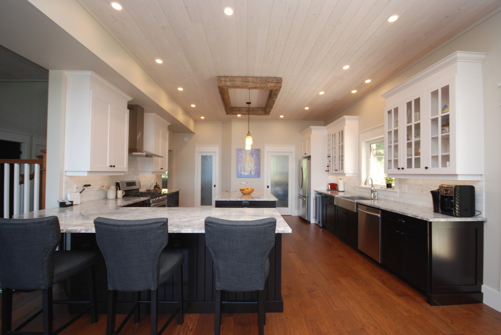 Inspiration for a large transitional galley medium tone wood floor open concept kitchen remodel in Ottawa with a farmhouse sink, shaker cabinets, dark wood cabinets, quartzite countertops, white backsplash, stone tile backsplash and stainless steel appliances