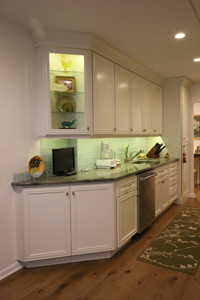 Photo of a small traditional galley kitchen in Philadelphia with a single-bowl sink, recessed-panel cabinets, white cabinets, granite worktops, green splashback, glass tiled splashback, stainless steel appliances and light hardwood flooring.