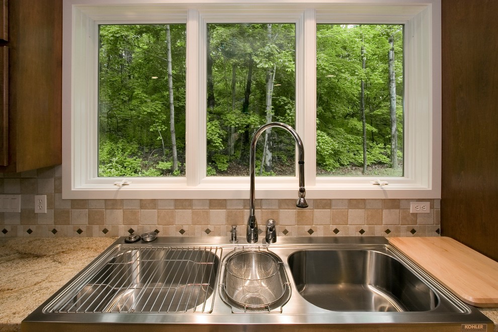 Foto de cocina clásica renovada con fregadero de doble seno, puertas de armario de madera oscura y electrodomésticos de acero inoxidable