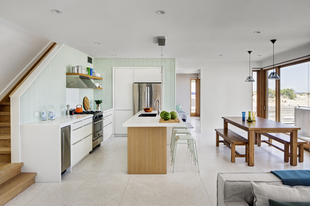 Modelo de cocina minimalista con fregadero bajoencimera, salpicadero gris, electrodomésticos de acero inoxidable, suelo de terrazo, una isla y suelo blanco