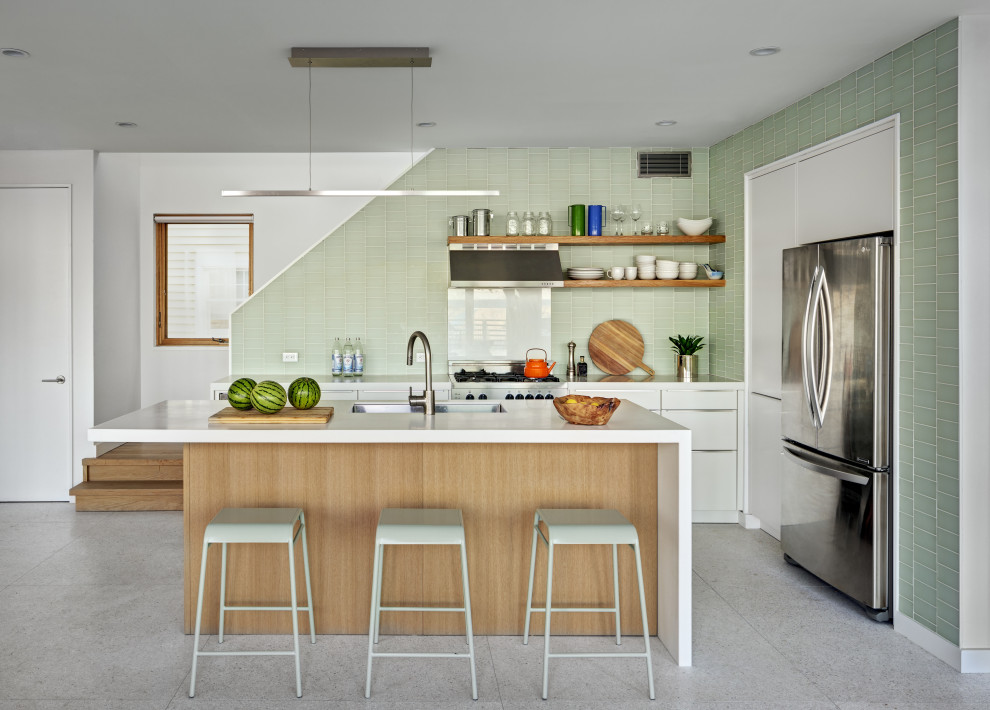Exempel på ett maritimt kök, med en undermonterad diskho, släta luckor, vita skåp, grönt stänkskydd, rostfria vitvaror, terrazzogolv, en köksö och vitt golv