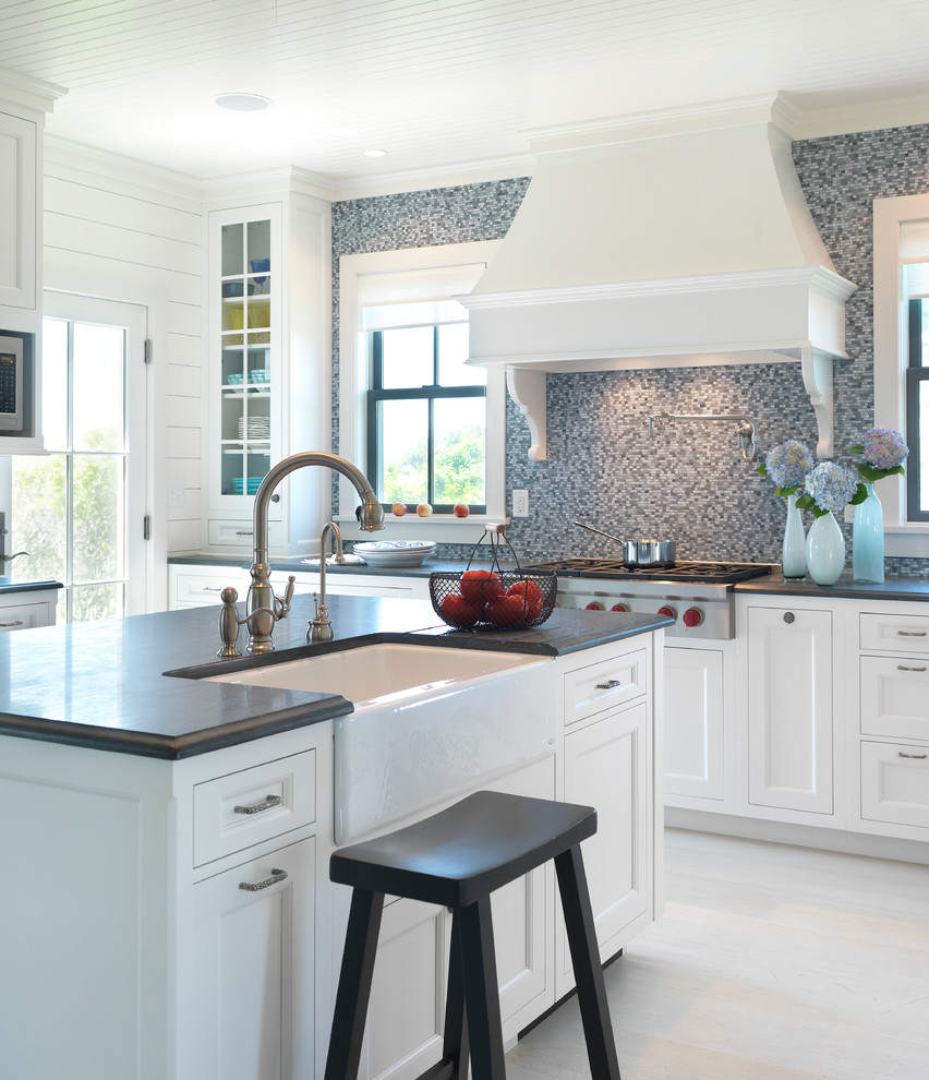 Kitchen - coastal kitchen idea in Boston with a farmhouse sink, recessed-panel cabinets, white cabinets, wood countertops, gray backsplash, mosaic tile backsplash and stainless steel appliances