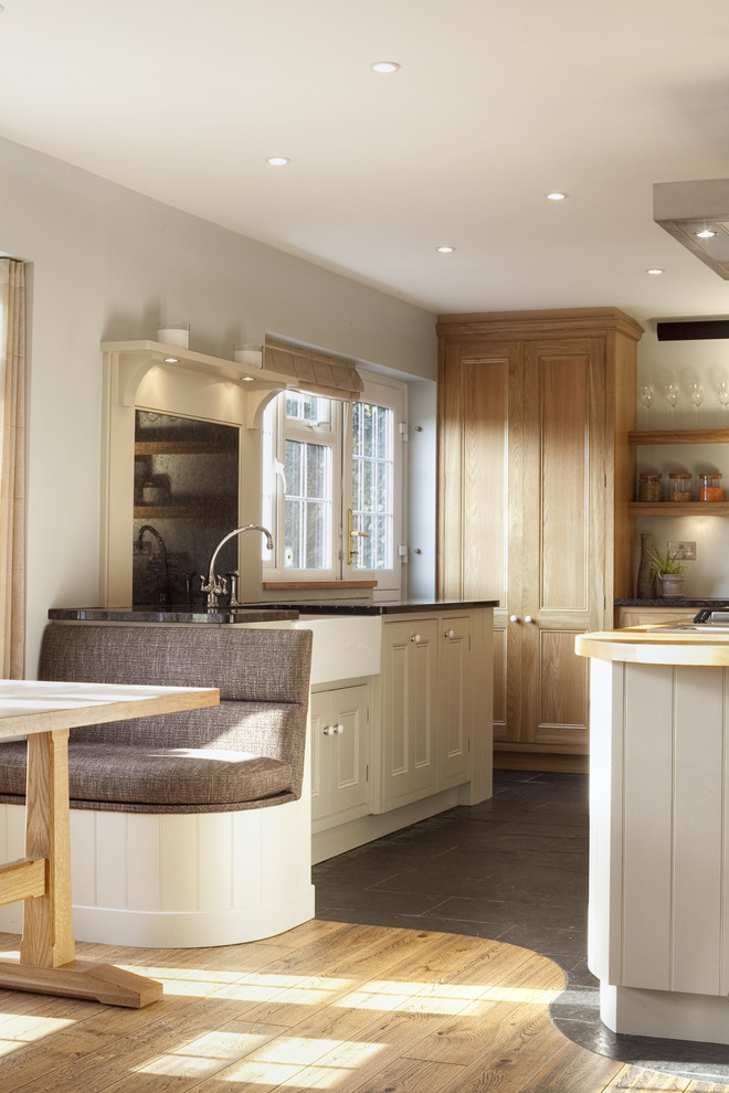 Klassische Küche mit Küchengeräten aus Edelstahl, Landhausspüle und Granit-Arbeitsplatte in London