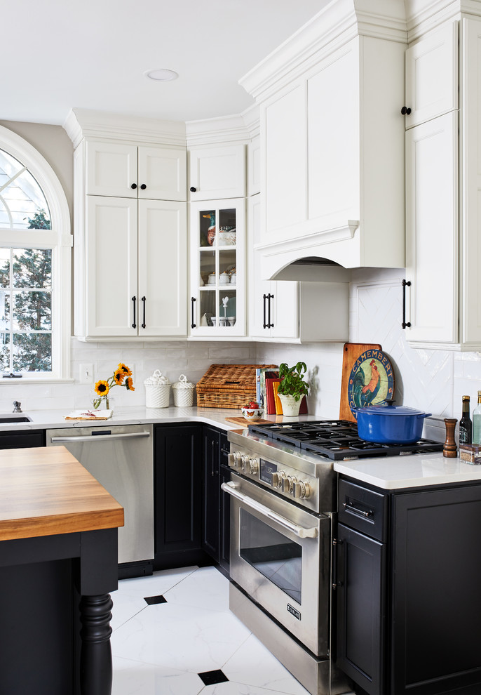 Mid-sized country l-shaped porcelain tile and white floor eat-in kitchen photo in Chicago with a farmhouse sink, shaker cabinets, white cabinets, quartz countertops, white backsplash, porcelain backsplash, stainless steel appliances, an island and white countertops