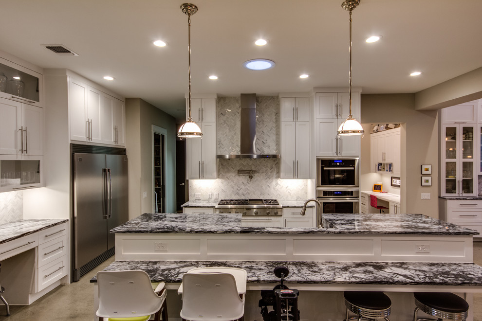 Eat-in kitchen - large modern l-shaped concrete floor and gray floor eat-in kitchen idea in Austin with marble countertops, stainless steel appliances, an island, shaker cabinets, white cabinets, gray backsplash, porcelain backsplash, a farmhouse sink and multicolored countertops