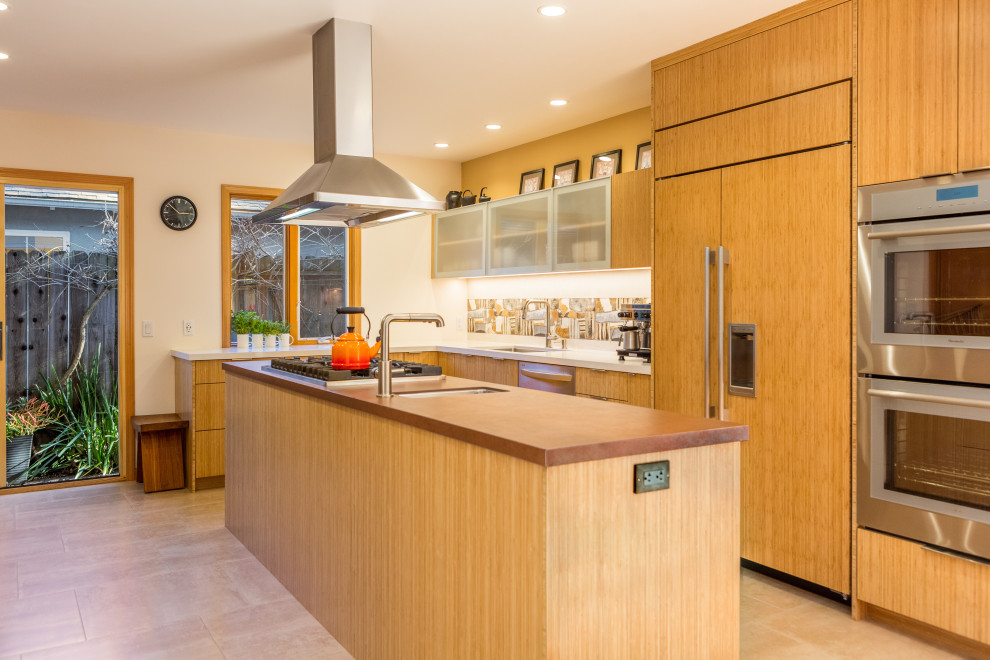 Example of a mid-sized trendy galley ceramic tile eat-in kitchen design in San Francisco with an undermount sink, flat-panel cabinets, medium tone wood cabinets, tile countertops, multicolored backsplash, ceramic backsplash, paneled appliances, an island and brown countertops