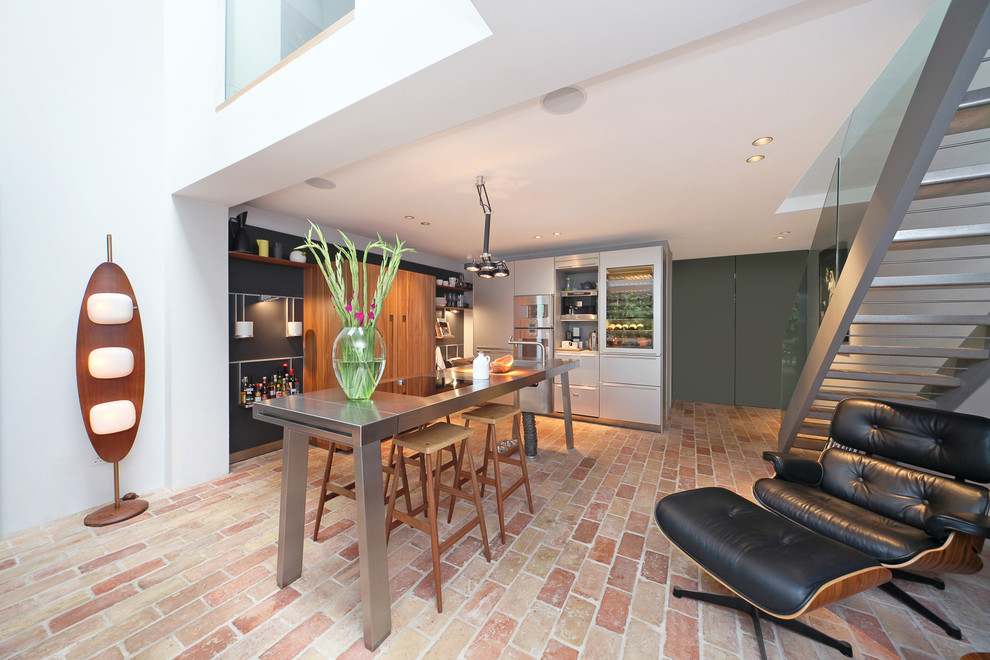 Moderne Küche in L-Form mit flächenbündigen Schrankfronten, weißen Schränken, Backsteinboden und Kücheninsel in London