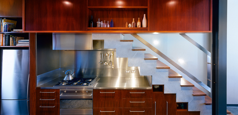 Foto de cocina contemporánea con puertas de armario de madera oscura y encimera de acero inoxidable