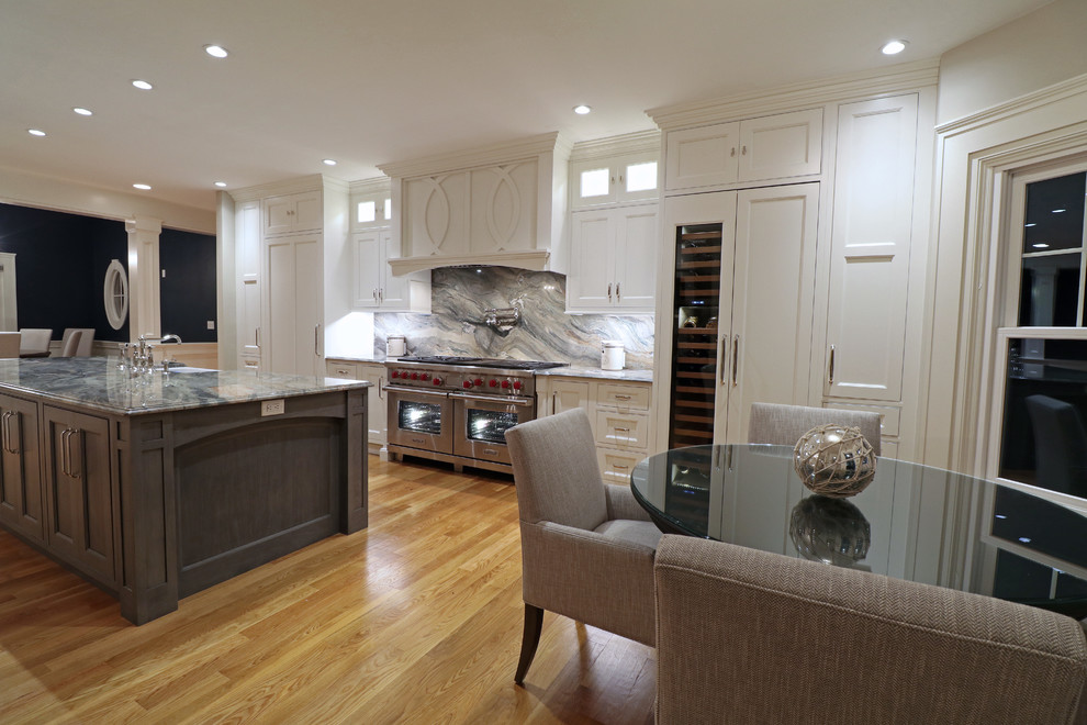 Exempel på ett stort klassiskt flerfärgad linjärt flerfärgat kök och matrum, med en rustik diskho, luckor med profilerade fronter, vita skåp, granitbänkskiva, flerfärgad stänkskydd, stänkskydd i sten, rostfria vitvaror, ljust trägolv, flera köksöar och gult golv