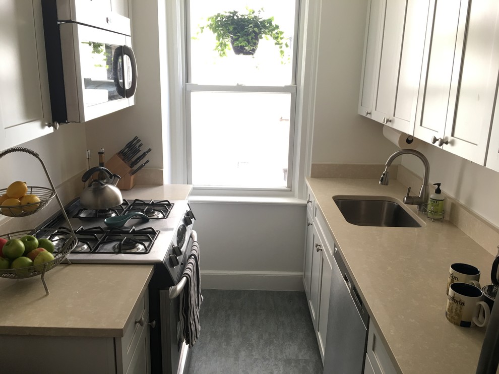 Small classic enclosed kitchen in New York with recessed-panel cabinets, white cabinets, white splashback, stainless steel appliances, lino flooring and blue floors.