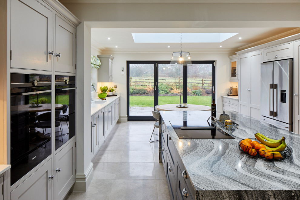 Inspiration for a large country u-shaped open concept kitchen remodel in Kent with recessed-panel cabinets, quartzite countertops and two islands