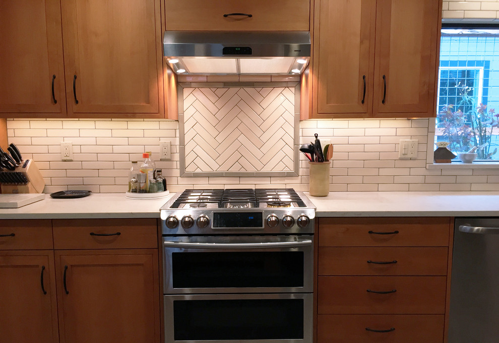 Mid-sized mid-century modern galley ceramic tile and gray floor eat-in kitchen photo in Other with an integrated sink, flat-panel cabinets, medium tone wood cabinets, soapstone countertops, white backsplash, ceramic backsplash, stainless steel appliances and no island