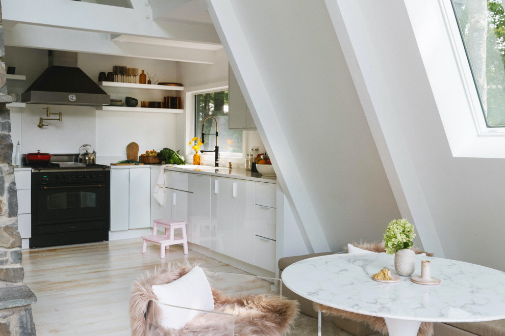 Ispirazione per una piccola cucina abitabile moderna con parquet chiaro, pavimento beige e travi a vista