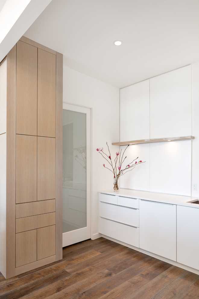 Moderne Wohnküche mit flächenbündigen Schrankfronten, weißen Schränken und Kücheninsel in Portland