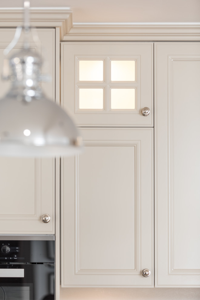 Ejemplo de cocina moderna con armarios estilo shaker, puertas de armario beige y electrodomésticos de acero inoxidable