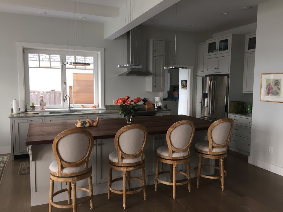 Photo of a medium sized contemporary kitchen/diner in Providence with a submerged sink, shaker cabinets, grey cabinets, wood worktops, stainless steel appliances, dark hardwood flooring and an island.