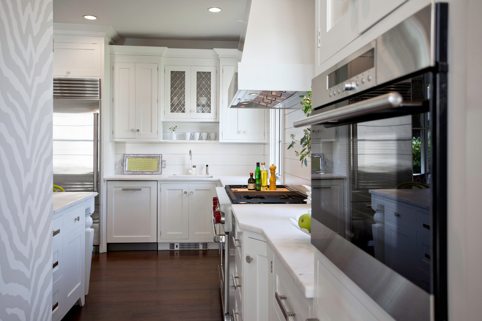 Ejemplo de cocinas en L clásica renovada con armarios estilo shaker, puertas de armario blancas y electrodomésticos de acero inoxidable