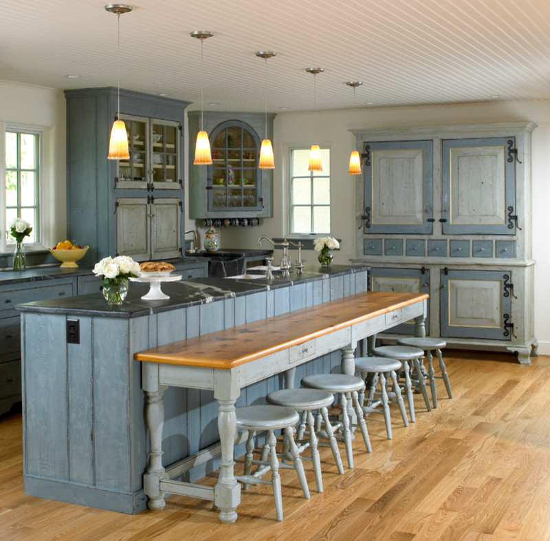Exempel på ett stort klassiskt kök, med en enkel diskho, luckor med glaspanel, blå skåp, bänkskiva i kalksten, vitt stänkskydd, rostfria vitvaror, ljust trägolv, en köksö och brunt golv