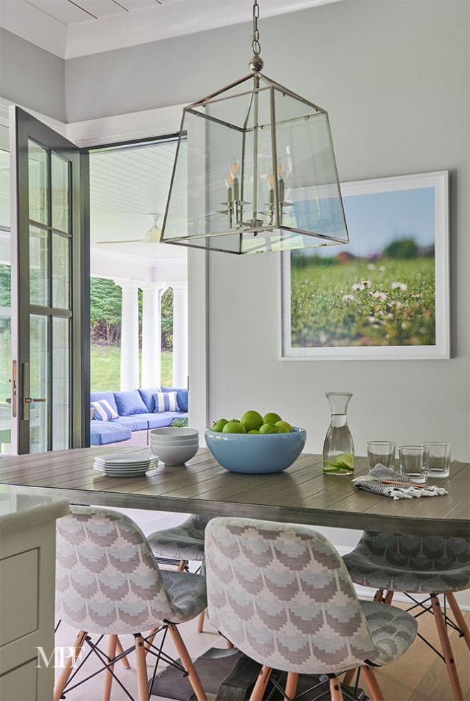 Immagine di una sala da pranzo aperta verso la cucina classica con parquet chiaro