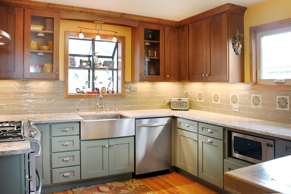This is an example of a medium sized farmhouse u-shaped enclosed kitchen in Other with a belfast sink, shaker cabinets, engineered stone countertops, grey splashback, stainless steel appliances, medium hardwood flooring, blue cabinets, metro tiled splashback, a breakfast bar and brown floors.