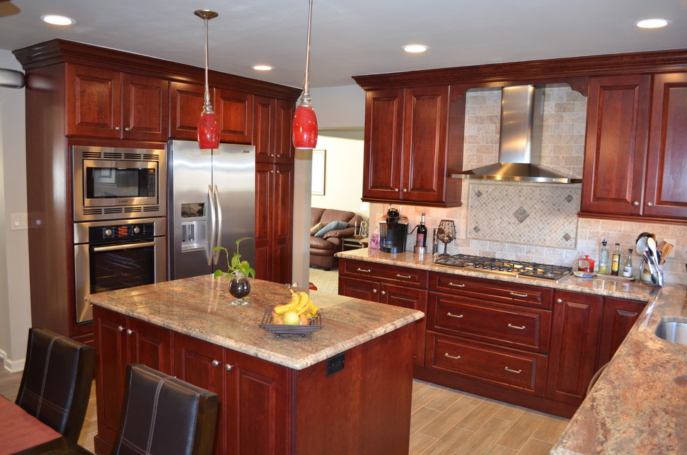 Wohnküche in U-Form mit profilierten Schrankfronten, roten Schränken, Granit-Arbeitsplatte, Küchenrückwand in Beige und Küchengeräten aus Edelstahl in Philadelphia