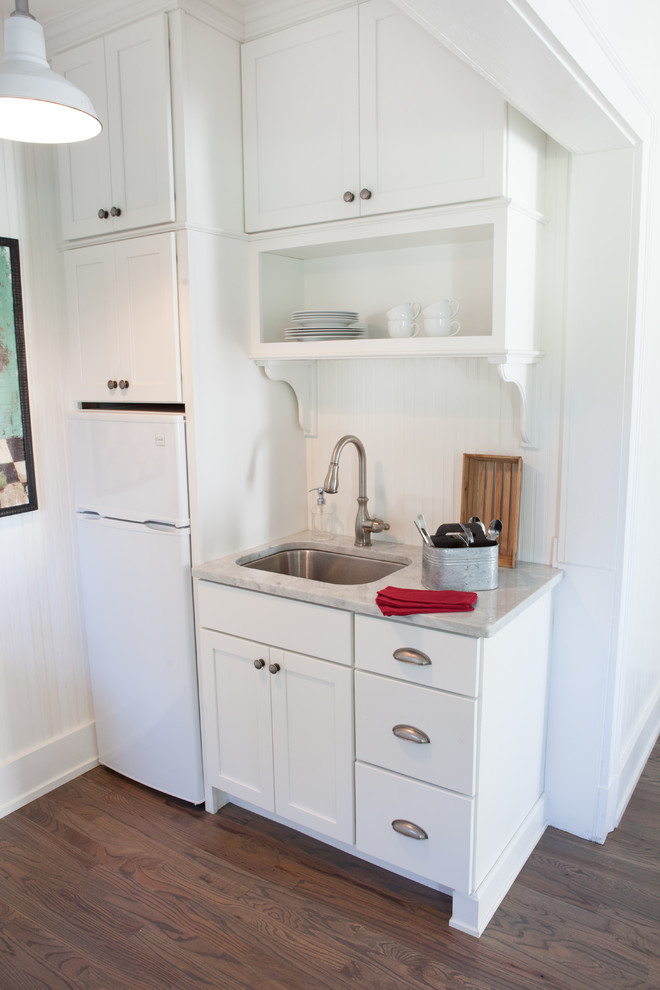 Inspiration för små lantliga linjära kök och matrum, med en undermonterad diskho, luckor med infälld panel, vita skåp, vitt stänkskydd, rostfria vitvaror, mellanmörkt trägolv och marmorbänkskiva