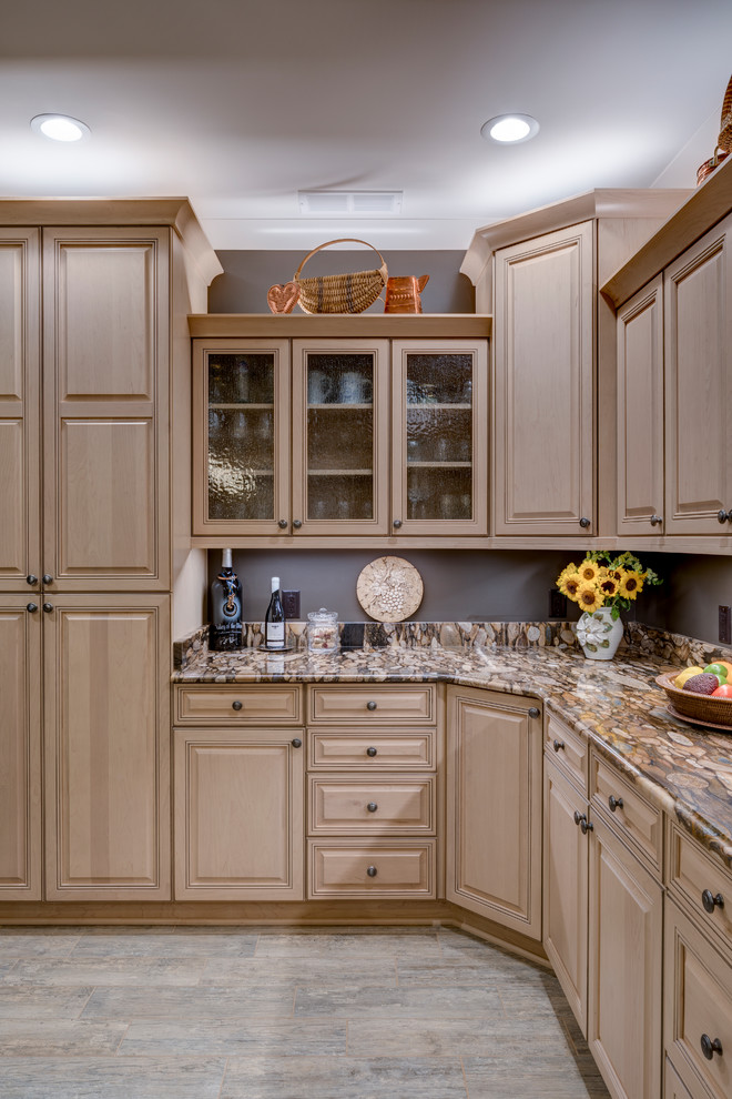 Large traditional u-shaped open plan kitchen in Other with a belfast sink, beaded cabinets, light wood cabinets, granite worktops, brown splashback, stone tiled splashback, stainless steel appliances, ceramic flooring, an island, brown floors and brown worktops.
