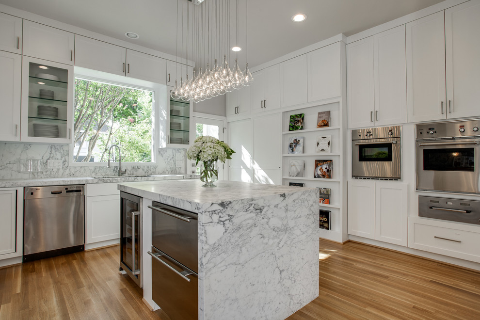 Kitchen - contemporary l-shaped kitchen idea in Dallas with recessed-panel cabinets, white cabinets, white backsplash and stainless steel appliances