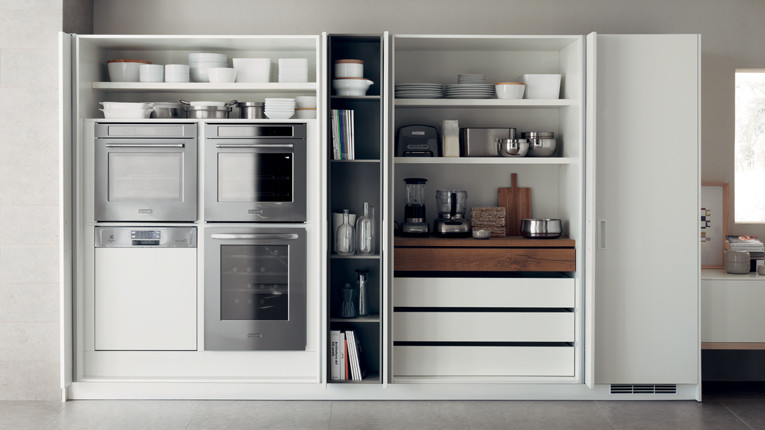 Inspiration pour une petite cuisine parallèle minimaliste fermée avec des portes de placard blanches, un plan de travail en bois, un électroménager en acier inoxydable, un sol en carrelage de céramique et îlot.