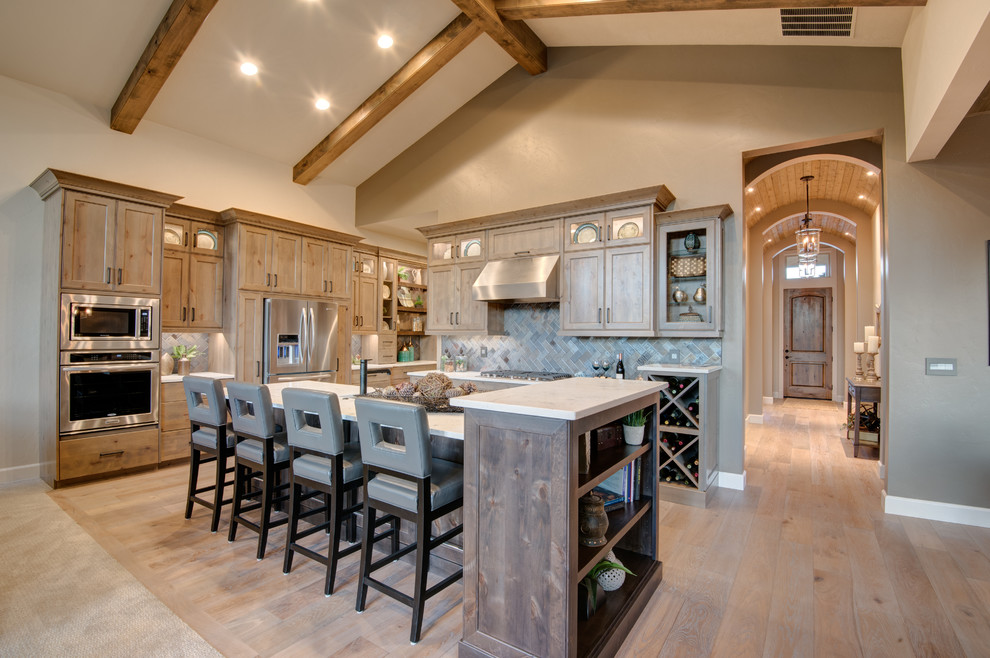 Inspiration for a large transitional l-shaped light wood floor and beige floor eat-in kitchen remodel in Boise with an undermount sink, shaker cabinets, light wood cabinets, marble countertops, gray backsplash, slate backsplash, stainless steel appliances and an island
