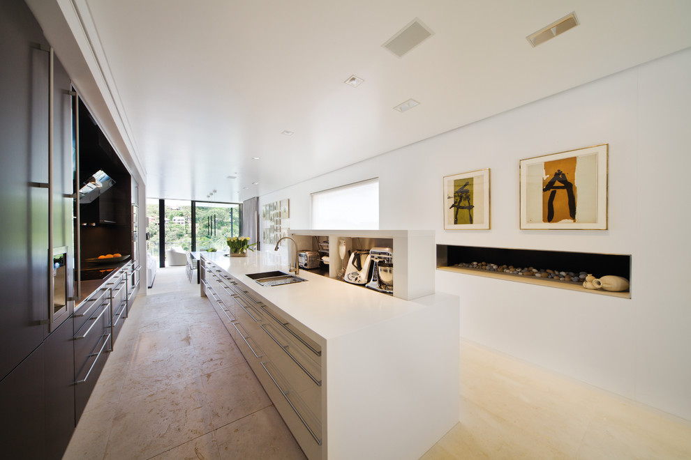 Modelo de cocina alargada moderna abierta con armarios con paneles lisos