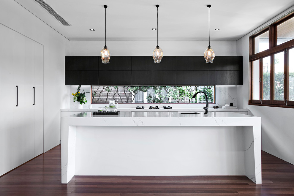 Zweizeilige Moderne Küche mit Unterbauwaschbecken, flächenbündigen Schrankfronten, Küchenrückwand in Weiß, dunklem Holzboden und Kücheninsel in Sydney